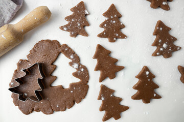 The process of making Christmas cookies. The photo shows the dough, rolling pin and molds for New Year's cookies on a white background. View from above.