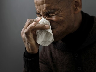 blowing nose after catching the cold and flu with grey background with people stock image stock...