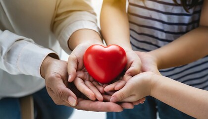 family hands holding red heart health care hope life insurance concept world heart day world health day adoption foster care home organ donor day csr social responsibility gratitude