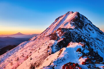 朝焼けの冠雪の富士山と八ヶ岳連峰の赤岳