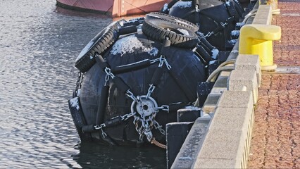 Large Port Ship Mooring Protective Fender Bumper Rubber Bouys Hanging at Wharf Quay	
