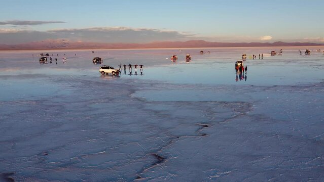 Tourist taking picure of their reflections in the water of the Salt flats on Salar De Uyuni in Bolivia