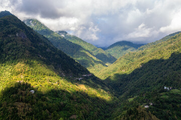 Fototapeta na wymiar travel to Georgia - gray clouds over overgrown mountains in Machakhela national park in Adjara on sunny autumn day