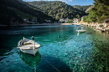 boat in the bay in crystal clear water with mountains in the background