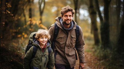 Obraz premium smiling son and father walking with backpacks through the forest, nature reserve, hiking, tall trees, blurred background, man, boy, trail, tourists, travel, hike, family, weekend together, child, kid