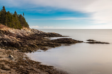 Serene coastal rocky beach with calm water