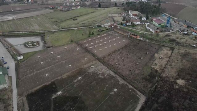 Aerial view of agricultural fields next to small ruined houses in Ub, Serbia