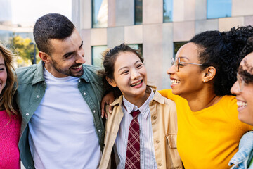 Millennial group of young happy friends laughing together at city street. Diversity and youth community concept with diverse millennial people having fun, celebrating at city street.