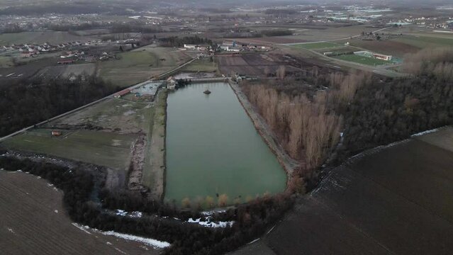 Drone flies around a lake in countryside in sunrise in Ub, Serbia