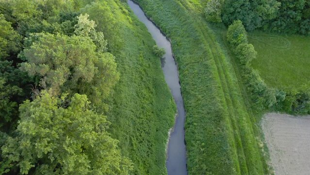 Drone flies around river Ub surrounded by greenery and agricultural fields in Serbia