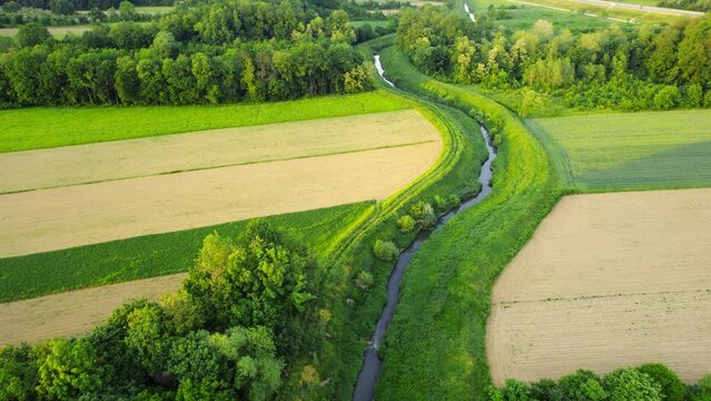 Drone flies around river Ub surrounded by greenery and agricultural fields in Serbia