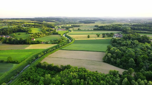 Drone flies around river Ub surrounded by greenery and agricultural fields in Serbia