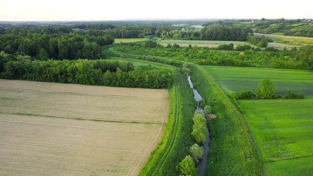 Drone flies around river Ub surrounded by greenery and agricultural fields in Serbia