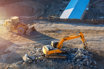 Excavator and bulldozer in construction site. Excavation is the process of moving earth, rock or...