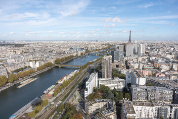 Beautiful aerial view of the city of Paris, taken from the Generali Balloon, Parc André-Citroën in the 15th arrondissement. We can see the Seine river, the Eiffel Tower and a lot of buildings. - obrazy, fototapety, plakaty