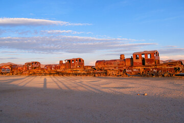 Ruins of dozens of rusted vintage train locomotives at the train cemetery in Uyuni, Bolivia