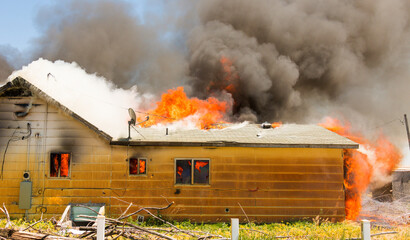 Firemen battle a house blaze that has consumed the entire building'
