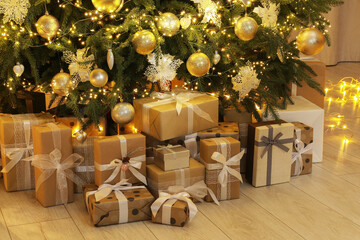 Many gift boxes under decorated Christmas tree at home