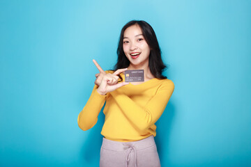 Asian woman posing with a credit card, Portrait of a beautiful young woman in a light blue...