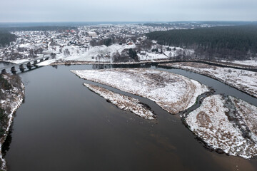 Beautiful winter aerial landscape. A river and a lake forming islets along the coast, with a river...