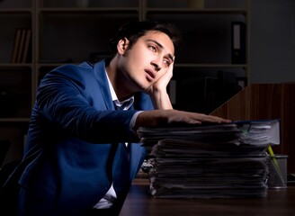 Fototapeta premium Young male employee working night in the office