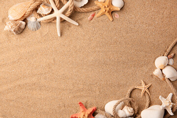 Beautiful sea stars, shells and ropes on sand, flat lay. Space for text