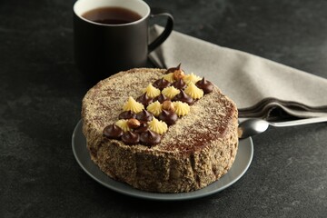 Delicious Kyiv Cake with cream and hazelnuts served on black table
