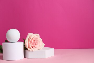 Stylish presentation of product. Beautiful rose and geometric figures on pink table, space for text