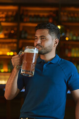 Hombre latino con una cerveza en un bar con colores calidos. con espacio para copy y diseños con expresiones 