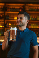 Hombre latino con una cerveza en un bar con colores calidos. con espacio para copy y diseños con expresiones 