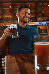 Hombre latino con una cerveza en un bar con colores calidos. con espacio para copy y diseños con expresiones 