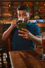 Hombre latino con una cerveza en un bar con colores calidos. con espacio para copy y diseños con expresiones 