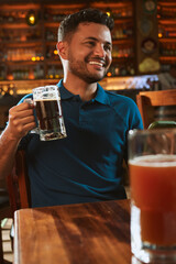 Hombre latino con una cerveza en un bar con colores calidos. con espacio para copy y diseños con...
