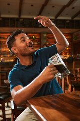 Hombre latino con una cerveza en un bar con colores calidos. con espacio para copy y diseños con...