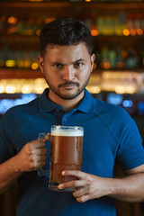 Hombre latino con una cerveza en un bar con colores calidos. con espacio para copy y diseños con expresiones 