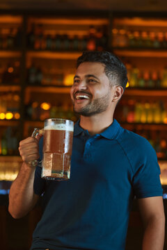 Hombre latino con una cerveza en un bar con colores calidos. con espacio para copy y dise&ntilde;os con expresiones 