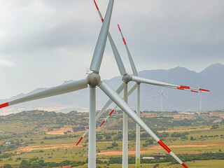 Panoramic view of wind farm or wind park, with high wind turbines for generation electricity with copy space on rice field, Ninh Thuan, Vietnam. Green energy concept.