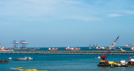 Naklejka premium Logistic shipping quay boat Engineering crane depot at logistic export terminal control. Warehouse freight background container yard loading quayside harbor port. Logistics seascape shipping portal