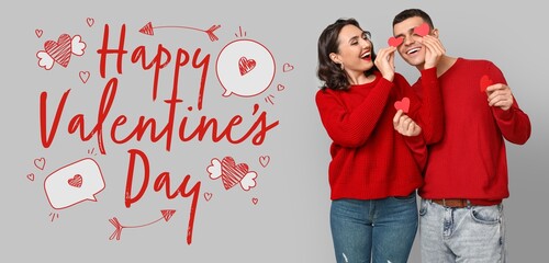 Young couple with red hearts and text HAPPY VALENTINE'S DAY on grey background