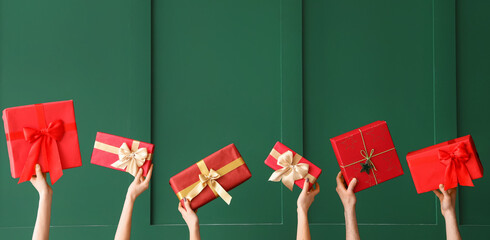 Many hands with Christmas gifts on green background