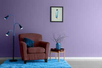 Interior of room with comfortable armchair and table near lilac wall. Banner for design