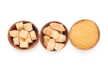 Bowls with different types of sugar on white background