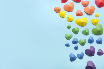 Colorful hearts made of paper on blue background. LGBT concept