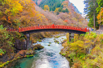 Fototapeta na wymiar Japan-November 13, 2023 : Scenic Landscape of Shinkyo Bridge surrounding with Colorful maple trees in Autumn, Shinkyo bridge is one of most famous landmark of Nikko, Tochigi