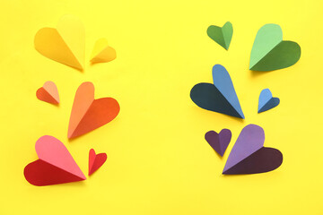 Colorful paper hearts on yellow background. LGBT concept
