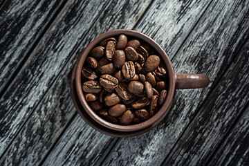 Roasted Coffee Beans In Cup On Wooden Background.