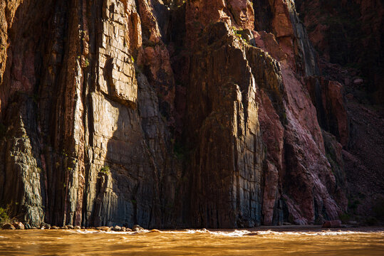 The Colorado River flows below dark sun-raked cliffs along the South Kaibab Trail, Grand Canyon National Park