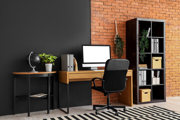 Interior of modern office with workplace, shelf unit and table