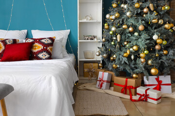 Interior of bedroom with big bed, Christmas tree and presents