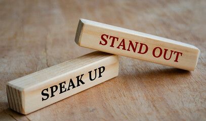 Stand out and speak up text on wooden blocks. Business concept